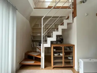 a staircase in a living room with a book shelf at Asakusa Loft in Tokyo