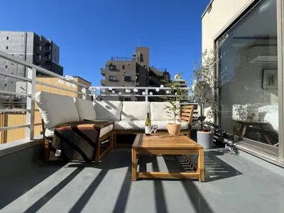 a patio with a couch and a table on a balcony at Asakusa Loft in Tokyo