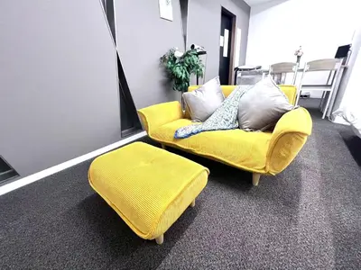a yellow chair and a ottoman in a room at \u6751\u4e0a\u7fa9\u7537\u30c7\u30b6\u30a4\u30f3 \u6771\u4eac\u90fd\u5fc3 \u5b8c\u5168\u8cb8\u5207 \u6620\u753b\u5ba4 \u6c60\u888b\u96fb\u8eca6\u5206 \u65b0\u5bbf\u6e0b\u8c37\u76f4\u901a \u30b7\u30e7\u30c3\u30d4\u30f3\u30b0\u306b\u4fbf\u5229 WiFi \u9577\u671fOK WAGAMAMA\u5c0f\u7af9\u5411\u539fTAKA 102\u5ba4 in Tokyo