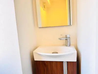 a bathroom with a white sink and a mirror at \u6751\u4e0a\u7fa9\u7537\u30c7\u30b6\u30a4\u30f3 \u6771\u4eac\u90fd\u5fc3 \u5b8c\u5168\u8cb8\u5207 \u6620\u753b\u5ba4 \u6c60\u888b\u96fb\u8eca6\u5206 \u65b0\u5bbf\u6e0b\u8c37\u76f4\u901a \u30b7\u30e7\u30c3\u30d4\u30f3\u30b0\u306b\u4fbf\u5229 WiFi \u9577\u671fOK WAGAMAMA\u5c0f\u7af9\u5411\u539fTAKA 102\u5ba4 in Tokyo