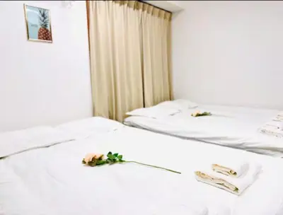 two beds in a room with flowers on them at \u6771\u4eac\u90fd\u5fc3\u5b8c\u5168\u8cb8\u5207 \u6620\u753b\u5ba4\u6c60\u888b\u96fb\u8eca6\u5206\u65b0\u5bbf\u6e0b\u8c37\u76f4\u901aWiFI \u9577\u671fOK WAGAMAMA\u5c0f\u7af9\u5411\u539fFUJI 101\u5ba4 in Tokyo