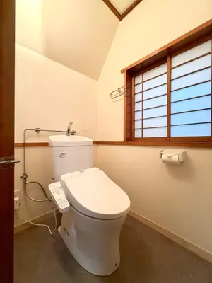 a white toilet in a bathroom with a window at \u7af9\u5185\u30d3\u30eb301 in Tokyo