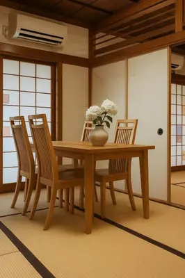 a dining room table with chairs and a vase with flowers at \u7af9\u5185\u30d3\u30eb301 in Tokyo
