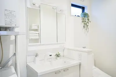 a white bathroom with a sink and a mirror at Tomo House Yotsuya-Sanchome 201 - from 6 minutes station \u56db\u8c37\u4e09\u4e01\u76ee 201 \u99c5\u304b\u3089\u5f92\u6b696\u5206 in Tokyo