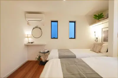 a bedroom with two beds and a mirror and windows at Tomo House Yotsuya-Sanchome 201 - from 6 minutes station \u56db\u8c37\u4e09\u4e01\u76ee 201 \u99c5\u304b\u3089\u5f92\u6b696\u5206 in Tokyo