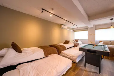 a room with four beds and a ping pong table at \u4e94\u53cd\u91ce in Tokyo