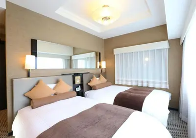 a hotel room with two beds and a mirror at APA Hotel Shinagawa Sengakuji Ekimae in Tokyo