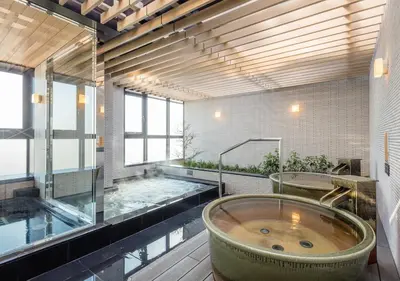 a large bathroom with two tubs and a pool at APA Hotel Shinagawa Sengakuji Ekimae in Tokyo