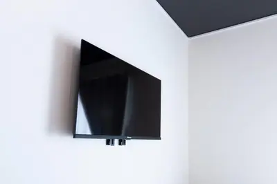 a flat screen tv hanging on a white wall at Forest Side Yoyogi Park 202 in Tokyo