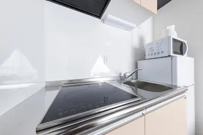 a kitchen with a sink and a microwave at Forest Side Yoyogi Park 202 in Tokyo