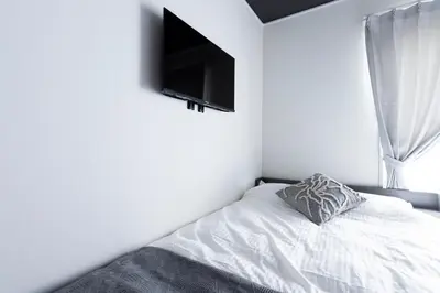 a bedroom with a bed with a television on the wall at Forest Side Yoyogi Park 202 in Tokyo