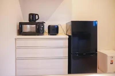 a microwave sitting on a counter next to a refrigerator at japan House\u30b9\u30ab\u30a4\u30c4\u30ea\u30fc\u99c5\u5f92\u6b695\u5206\u30f4\u30a3\u30e9\u8cb8\u5207 2\u53f7\u9928 in Tokyo
