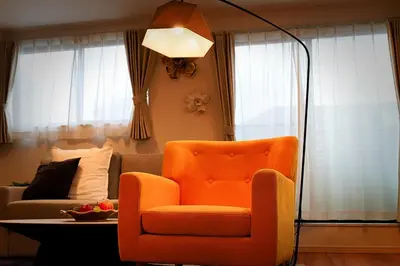 a living room with an orange chair and a couch at Tomo House Yotsuya-Sanchome 301 - from 6 minutes station \u56db\u8c37\u4e09\u4e01\u76ee 301 \u99c5\u304b\u3089\u5f92\u6b696\u5206 in Tokyo