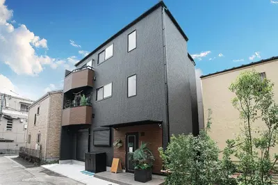 a black house with white windows on a street at Tomo House Yotsuya-Sanchome 301 - from 6 minutes station \u56db\u8c37\u4e09\u4e01\u76ee 301 \u99c5\u304b\u3089\u5f92\u6b696\u5206 in Tokyo
