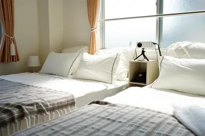 a bedroom with two beds and a window at Tomo House Oshiage - from 2 minutes station \u62bc\u4e0a \u99c5\u304b\u3089\u5f92\u6b692\u5206 in Tokyo