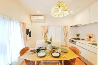 a dining room table with chairs and a kitchen at Tomo House Otsuka - from 6 minutes station \u5927\u585a \u99c5\u304b\u3089\u5f92\u6b696\u5206 in Tokyo