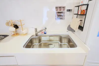a stainless steel sink in a white kitchen at Tomo House Otsuka - from 6 minutes station \u5927\u585a \u99c5\u304b\u3089\u5f92\u6b696\u5206 in Tokyo