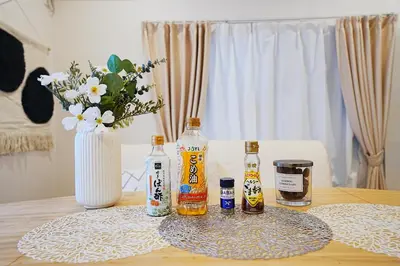 a table with bottles of alcohol and a vase of flowers at Tomo House Otsuka - from 6 minutes station \u5927\u585a \u99c5\u304b\u3089\u5f92\u6b696\u5206 in Tokyo
