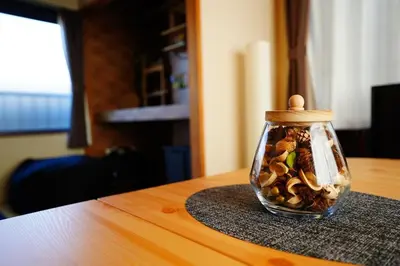a glass jar filled with shells on a table at Tomo House \u897f\u65b0\u5bbf\u4e94\u4e01\u76ee\u30a2\u30d1\u30fc\u30c8 303 in Tokyo