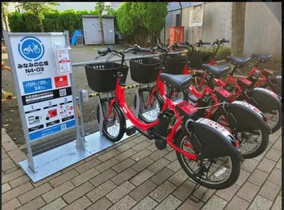 a row of bikes parked next to a sign at Tomo House \u897f\u65b0\u5bbf\u4e94\u4e01\u76ee\u30a2\u30d1\u30fc\u30c8 303 in Tokyo