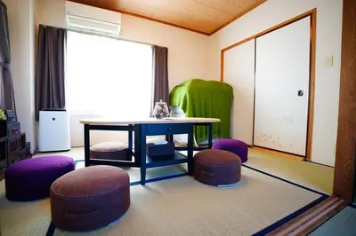 a room with a table and stools and a window at Tomo House \u897f\u65b0\u5bbf\u4e94\u4e01\u76ee\u30a2\u30d1\u30fc\u30c8 303 in Tokyo