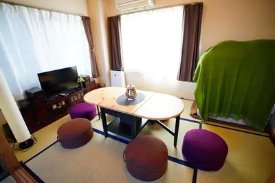 a living room with a table and some chairs at Tomo House \u897f\u65b0\u5bbf\u4e94\u4e01\u76ee\u30a2\u30d1\u30fc\u30c8 303 in Tokyo
