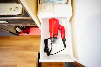 a red cordless drill is hanging from a wall at Tomo House \u897f\u65b0\u5bbf\u4e94\u4e01\u76ee\u30a2\u30d1\u30fc\u30c8 303 in Tokyo
