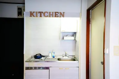 a kitchen with a sink and a sign that reads kitchen at Tomo House \u897f\u65b0\u5bbf\u4e94\u4e01\u76ee\u30a2\u30d1\u30fc\u30c8 301 in Tokyo