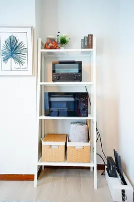 a white book shelf with a printer and other items at Tomo House \u897f\u65b0\u5bbf\u4e94\u4e01\u76ee\u30a2\u30d1\u30fc\u30c8 301 in Tokyo