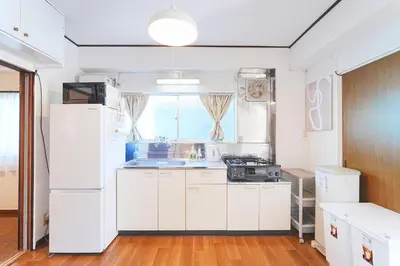 a kitchen with white appliances and a large window at Tomo House Yoyogi 301 - from 4 minutes station \u4ee3\u3005\u6728 301 \u99c5\u304b\u3089\u5f92\u6b694\u5206 in Tokyo