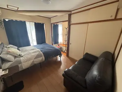 a bedroom with a bed and a leather couch at Jr\u5c71\u624b\u7ebf\u5927\u585a\u7ad9\u6b65\u884c2\u5206\u949f \u6771\u5357\u793e3\u53f7 in Tokyo