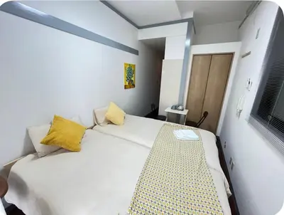 a bedroom with a large white bed with yellow pillows at Comfy House \u5e73\u4e95\u99c5\u5f92\u6b695\u5206\u96fb\u8eca\u3067\u79cb\u8449\u539f11\u5206\u6771\u4eac\u99c516\u5206\u62bc\u4e0a17\u5206\u65b0\u5bbf26\u5206\u9280\u5ea730\u5206\u4e0a\u91ce20\u5206\u6e0b\u8c3736\u5206 in Tokyo