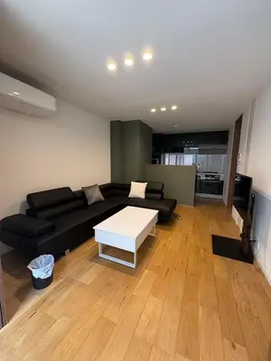 a living room with a black couch and a white table at \u9759\u8c27\u65f6\u5149 1f in Tokyo