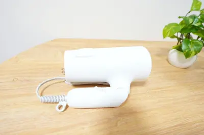 a white hair dryer sitting on a table with a plant at Aki Hiroo Stay 101 in Tokyo