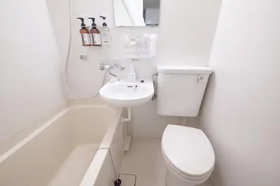 a white bathroom with a toilet and a sink at Aki Shin-Okubo Stay 105 in Tokyo
