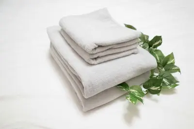 a pile of towels sitting on a table with leaves at Aki Shin-Okubo Stay 105 in Tokyo