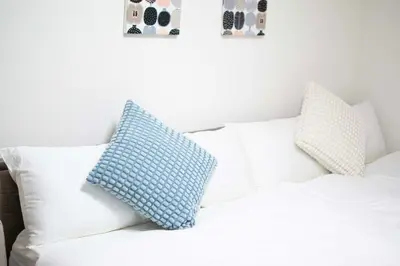 a blue pillow sitting on top of a white couch at Aki Shin-Okubo Stay 105 in Tokyo