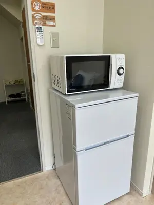 a microwave sitting on top of a refrigerator at \u65b0\u7530201\u6210\u7530\u7fbd\u7530\u673a\u573a\u76f4\u8fbe\u6b65\u884c\u53ef\u62b5\u8fbe\u79cb\u53f6\u539f\u6700\u8fd1\u8f66\u7ad95\u5206\u949f in Tokyo