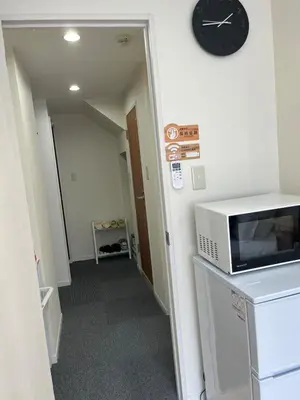 a hallway with a microwave and a clock on a wall at \u65b0\u7530201\u6210\u7530\u7fbd\u7530\u673a\u573a\u76f4\u8fbe\u6b65\u884c\u53ef\u62b5\u8fbe\u79cb\u53f6\u539f\u6700\u8fd1\u8f66\u7ad95\u5206\u949f in Tokyo