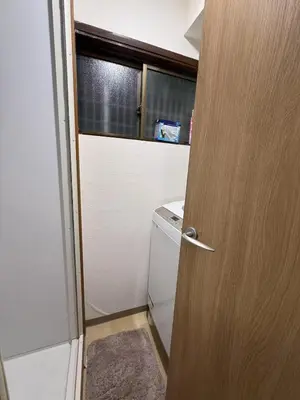 a bathroom with a door and a washer and dryer at \u79cb\u53f6\u539f\u6c11\u5bbf\u6210\u7530\u7fbd\u7530\u673a\u573a\u53ef\u4ee5\u76f4\u8fbe\u6b65\u884c10\u5206\u949f\u62b5\u8fbe\u8f66\u7ad9\u4ea4\u901a\u4fbf\u5229\u5b89\u9759\u53ef\u5165\u4f4f10\u4eba in Tokyo
