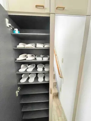 a closet with stairs with white bowls and a refrigerator at Shinkoiwa Matsushima HOUSE in Tokyo