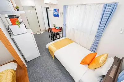 a small room with two beds and a table at Akihabara Skytree Premium Apartment 201 in Tokyo