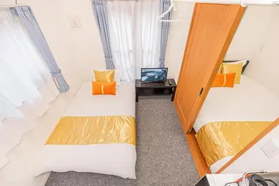 two beds in a small room with a tv at Akihabara Skytree Premium Apartment 301 in Tokyo