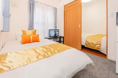 a bedroom with a large bed with an orange pillow at Akihabara Skytree Premium Apartment 301 in Tokyo