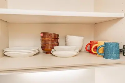 a shelf with bowls and plates and cups on it at Akihabara Skytree Premium Apartment 301 in Tokyo