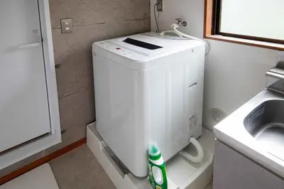 a small washing machine in a bathroom next to a sink at \u5927\u6cb3\u5185\u30b3\u30fc\u30dd301 \u6700\u59273\u540d \u8cb8\u5207 \u672c\u6240\u543e\u59bb\u6a4b\u99c5\u5f92\u6b6910\u5206 20\u5e73\u7c73 in Tokyo