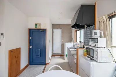 a kitchen with a blue door in a kitchen at \u5927\u6cb3\u5185\u30b3\u30fc\u30dd301 \u6700\u59273\u540d \u8cb8\u5207 \u672c\u6240\u543e\u59bb\u6a4b\u99c5\u5f92\u6b6910\u5206 20\u5e73\u7c73 in Tokyo
