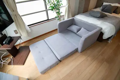 a living room with a couch and a bed at \u5927\u6cb3\u5185\u30b3\u30fc\u30dd301 \u6700\u59273\u540d \u8cb8\u5207 \u672c\u6240\u543e\u59bb\u6a4b\u99c5\u5f92\u6b6910\u5206 20\u5e73\u7c73 in Tokyo