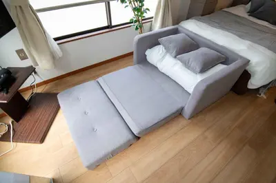 a living room with a couch and a bed at \u5927\u6cb3\u5185\u30b3\u30fc\u30dd301 \u6700\u59273\u540d \u8cb8\u5207 \u672c\u6240\u543e\u59bb\u6a4b\u99c5\u5f92\u6b6910\u5206 20\u5e73\u7c73 in Tokyo
