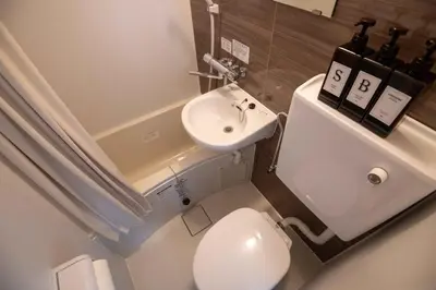 a small bathroom with a white toilet and a sink at \u5927\u6cb3\u5185\u30b3\u30fc\u30dd301 \u6700\u59273\u540d \u8cb8\u5207 \u672c\u6240\u543e\u59bb\u6a4b\u99c5\u5f92\u6b6910\u5206 20\u5e73\u7c73 in Tokyo